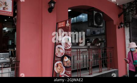 Lady on Mobile Phone ingresso al ristorante sulla Charoen Krung Road a Chinatown Bangkok Thailandia Foto Stock