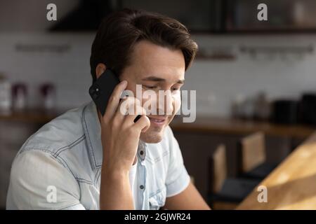 Sorridente giovane parla sul gadget smartphone Foto Stock