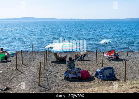 TREVIGNANO ROMANO ITALIA, REGNO UNITO. 12 Settembre 2021. La spiaggia è affollata di amanti del sole in una giornata calda sul lago di Bracciano, mentre famiglie e persone si presentano per il fine settimana da Roma alla località turistica di Trevignano Romano per godersi il sole mentre le temperature rimangono alte nel mese di settembre. Credit: amer Ghazzal/Alamy Live News Foto Stock