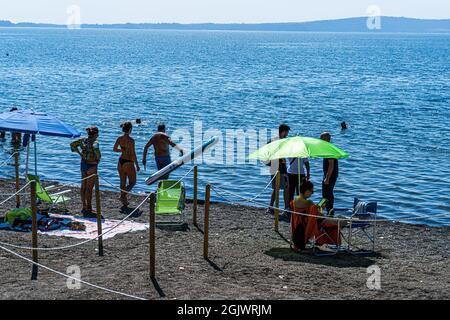 TREVIGNANO ROMANO ITALIA, REGNO UNITO. 12 Settembre 2021. La spiaggia è affollata di amanti del sole in una giornata calda sul lago di Bracciano, mentre famiglie e persone si presentano per il fine settimana da Roma alla località turistica di Trevignano Romano per godersi il sole mentre le temperature rimangono alte nel mese di settembre. Credit: amer Ghazzal/Alamy Live News Foto Stock