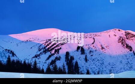 Un'incredibile alba in montagna con vette bianche. Una vista panoramica del coperto di gelo. Paesaggio naturale con bel cielo. Foto Stock