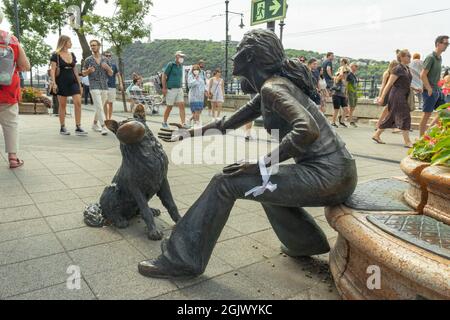 BUDAPEST, UNGHERIA - 19 AGOSTO 2021: Ragazza con la sua statua del cane a Budapest Foto Stock