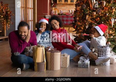 Famiglia etnica sorridente con bambini godersi il Natale a casa Foto Stock