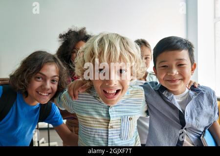 Ritratto di felice allegro sorridente bambini diversi divertirsi in classe. Foto Stock
