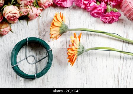 Tecniche di base per la sistemazione dei fiori: Cablaggio e nastratura delle gerbere. Foto Stock