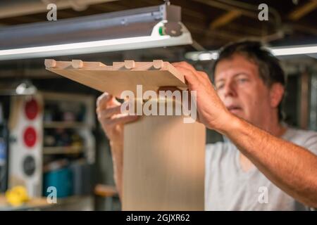 Uomo che si adatta insieme giunti a coda di rondine in legno shopt lavorazione. Foto Stock