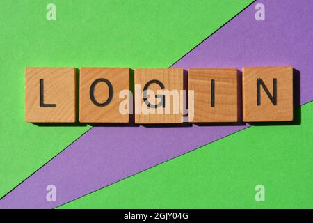 Login, parola in lettere in legno lettera isolata su verde e viola come titolo banner Foto Stock