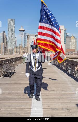I membri del Battaglione FDNY 57a Brooklyn conducono una precessione sul Ponte di Brooklyn alla Co-Cattedrale di St. Joseph. I marchers porteranno 25 bandiere, con 24 bandiere FDNY che rappresentano i 23 membri del battaglione 57 che sono stati persi al World Trade Center e un fratello di un membro del battaglione 57 che è morto anche quel giorno e una bandiera americana. New York City, NY USA 11 settembre 2021 (foto di Steve Sanchez/Sipa USA). Foto Stock