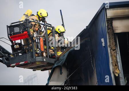 Berlino, Germania. 12 settembre 2021. I vigili del fuoco spengono un vecchio magazzino a Marzahn. Rifiuti ingombranti e pneumatici hanno bruciato nella sala. Credit: Christophe Gateau/dpa/Alamy Live News Foto Stock