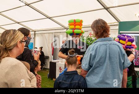 Walton Hall and Gardens, Warrington, Cheshire, Regno Unito. 12 settembre 2021. UK - Disability Awareness Day 30th Anniversary Event - The World's largest 'Not for profit' Voluntary-LED Disability Exhibition - Balloon art watched by Visitors Credit: John Hopkins/Alamy Live News Foto Stock