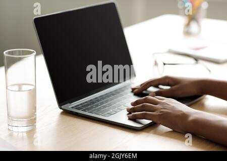 Adolescente afro ragazza americana pupilla digitando su portatile con schermo vuoto, ricerca info Foto Stock