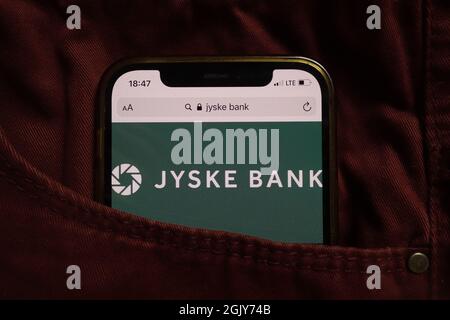 KONSKIE, POLONIA - 04 settembre 2021: Jyske Bank COME logo visualizzato sul cellulare nascosto in tasca jeans Foto Stock