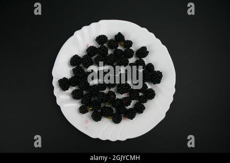 Nahaufnahme Weißer Teller mit Bio Obst Brombeeren Foto Stock