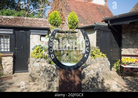 Shanklin Village, Isola di Wight, 2021. Una grande scarpetta da cavallo di buona fortuna con una piccola fontana, raccogliendo donazioni per un ospizio locale. Un pittoresco villag Foto Stock
