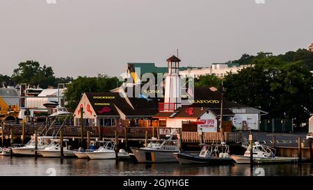 NORWALK, CT, USA - 12 SETTEMBRE 2021: Ristorante Waterside Dinning con bella luce dell'alba e barche attraccano nel fiume Norwalk vicino al centro Foto Stock