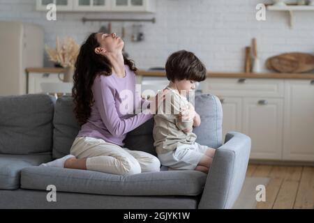 La madre frustrata stanca di figlio testardo offeso e sconvolto cercare di conforto ragazzino ignorando la mamma Foto Stock