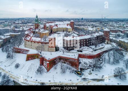 Skyline di Cracovia con lo storico Castello reale di Wawel e la Cattedrale in inverno. Neve bianca, persone a piedi e passeggiata Foto Stock