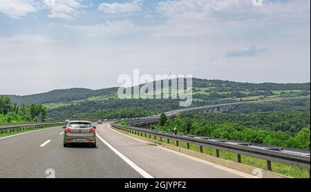 KIA Ceed e altre auto percorrono l'autostrada con un ponte a Plitvice, Croazia. Foto Stock