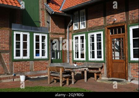 Area soggiorno di fronte a una casa rustica bassa Sassonia a graticcio Foto Stock