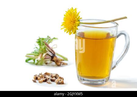 Tè Dandelion in bicchiere con fiore, foglie e radice su sfondo bianco. Foto Stock