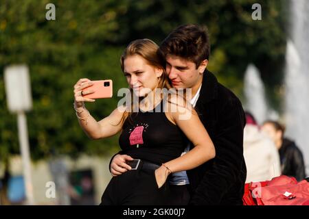 Russia San Pietroburgo 09.09.2021 Una giovane coppia fa un selfie su uno smartphone in un parco in estate. Foto di alta qualità Foto Stock