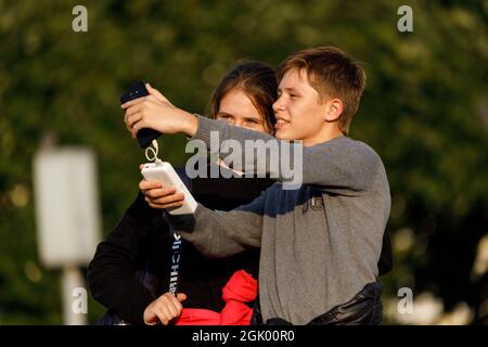 Russia San Pietroburgo 09.09.2021 Una giovane coppia fa un selfie su uno smartphone in un parco in estate. Foto di alta qualità Foto Stock