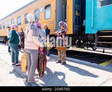 Donne che vendono pesce affumicato durante la sosta ai passeggeri del treno, stazione di Sary-Shagan, vicino al lago Balkhash, Kazakhstan, Asia centrale Foto Stock