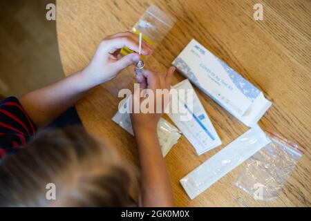 Tallinn, Estonia - 12 settembre 2021: COVID-19 AG Kit di prova per auto-test. Bambino che si sottopone a test per il coronavirus a casa. Foto Stock