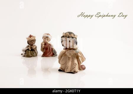 Felice giorno di Epifania concetto. Tre figure in ceramica di ragazzi saggi isolati su sfondo bianco. Biglietto di auguri. Spazio di copia. Messa a fuoco selettiva. Foto Stock