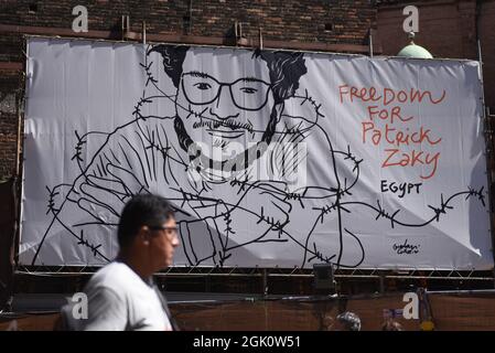 Bologna, Italia. 26 agosto 2021. Un uomo cammina per un banner che chiede la libertà del giornalista Patrick Zaky a Bologna.Patrick George Zaky, attivista egiziano di 27 anni e ricercatore per i diritti umani all'Università di Bologna, è bloccato in Egitto in detenzione preventiva per oltre un anno. Zaky viene indagato per cinque accuse diverse: Minaccia alla sicurezza nazionale, incitamento a manifestazioni illegali, sovversione, diffusione di notizie false e propaganda per il terrorismo. (Credit Image: © Jorge Sanz/SOPA Images via ZUMA Press Wire) Foto Stock