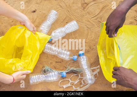 Mani selezionate bottiglia di scarto di plastica sulla spiaggia, spazzatura è sulla spiaggia. Volontari che raccolgono rifiuti sulla spiaggia. Concetto di ecologia. Foto Stock