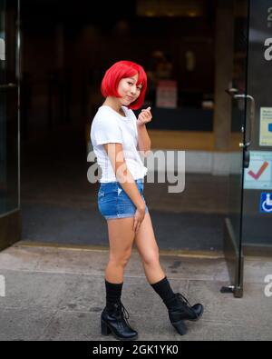 Teenage Asian Cosplay attrice di fronte al gelateria | Red Blood Cell Cosplay attrice di fronte al negozio Foto Stock