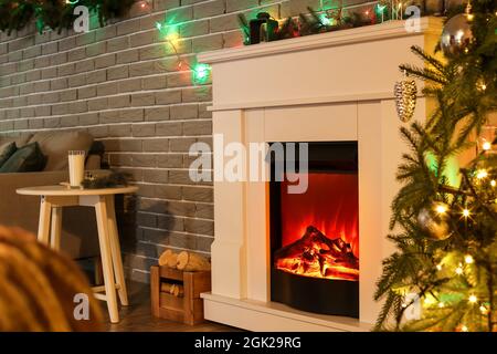 Camino moderno all'interno del soggiorno decorato per Natale Foto Stock