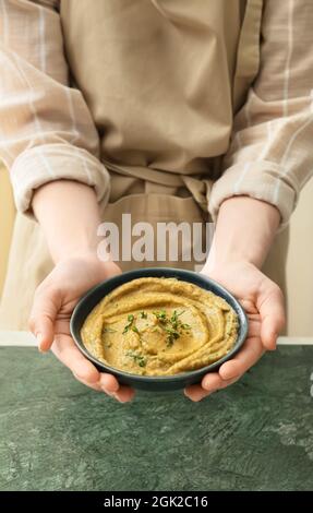 uomo che tiene ciotola con la ghanoush deliziosa del baba, primo piano Foto Stock