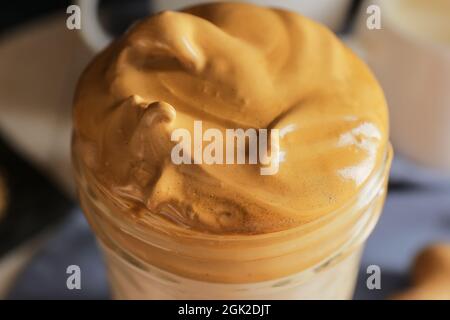 Bicchiere di gustoso dalgona hojicha latte sul tavolo, primo piano Foto Stock