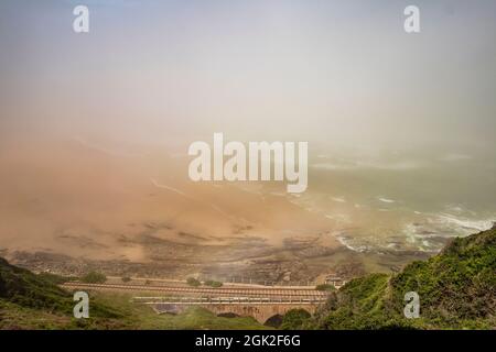 La vista della spiaggia del fiume Kaaiman con ponte ferroviario durante la mattinata di nebbia al Wilderness nella Garden Route di Western Cape, Sud Africa. Foto Stock