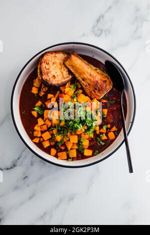 curry di pollo al burro vegano con sudore di zucca e parsnip sormontato con cioriandro fresco di produzione propria, ricette salutari a base di piante Foto Stock