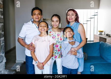 Ritratto di felice famiglia ispanica e figlia adolescente con paralisi cerebrale a casa in America Latina disabilità concetto Foto Stock