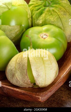 Tomatillos, pomodori verdi, ingredienti alimentari messicani su sfondo rustico scuro in legno, un primo piano Foto Stock