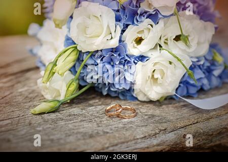 Bouquet di nozze bianco e blu con anelli di nozze su un albero vecchio. Foto di alta qualità Foto Stock