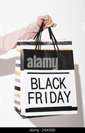 Primo piano dell'acquirente che tiene i sacchetti durante il Black Friday nel negozio Foto Stock