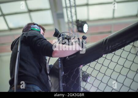 L'operatore mascherato spara un flusso sul Internet che trasmette a. un evento sportivo Foto Stock