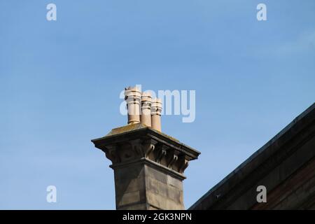 Un set di tre Chimney Pots in un edificio d'epoca. Foto Stock