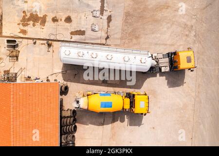 Vista aerea di due camion in officina di riparazione manutenzione, foto drone dall'alto in basso Foto Stock