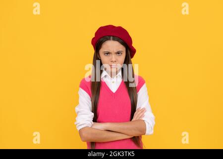 ragazza della scuola teen infelice in beretto francese su sfondo giallo, serietà Foto Stock