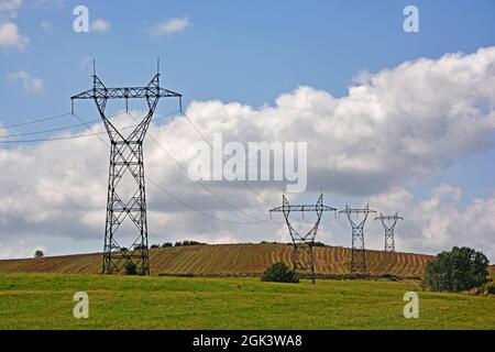 Linee elettriche ad alta tensione in campagna, Cezallier, Puy-de-Dome, Auvergne-Rhone-Alpes, Massif-Central, Francia Foto Stock