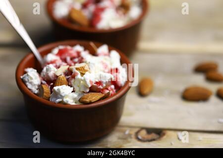 Una ciotola di formaggio caserario con condimenti e mandorle. Concetto di cibo sano. Pranzo dietetico o colazione. La dieta del keto. Foto Stock