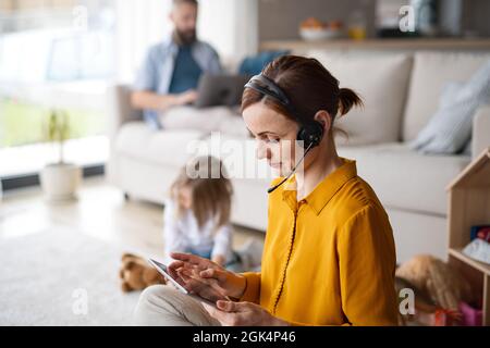 Donna d'affari con tablet che lavora in casa, nella vita quotidiana e in ufficio con concetto di bambino. Foto Stock