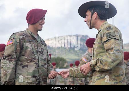 Jake Ellwood, il comandante della Joint Task Force 660, premia le ali onorarie del paracadute australiano ai paracadutisti dell'esercito degli Stati Uniti con il terzo battaglione, il 509° reggimento di fanteria del paracadutismo, il 4° team di combattimento delle Brigate di fanteria (Airborne), la 25° divisione di fanteria, Durante una cerimonia di premiazione come parte dell'esercitazione Talisman Saber 21 a Lavarack Barracks in Townsville, Queensland, Australia, 1 agosto 2021. I paracadutisti dell'Esercito degli Stati Uniti si sono guadagnati le ali onorarie australiane del paracadute il 28 luglio 2021, dove hanno condotto un'operazione di paracadute per garantire "Drop zone Kangaroo" vicino Charter Towers, Queens Foto Stock