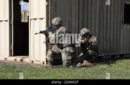 I soldati della Charlie Company, 1° Battaglione, 109° reggimento fanteria, 2° squadra di combattimento di Brigata di fanteria si coprono l'un l'altro come il resto della squadra si muovono in posizione durante il movimento della squadra e le esercitazioni di schiarimento della stanza il 2 agosto 2021 a Fort Indiantown Gap, Pa. Ogni squadra ha dovuto vincere una serie di sfide, tra cui navigare sotto il filo spinato, muoversi per coprire, dispiegare il fumo e reagire al fuoco indiretto. Foto Stock